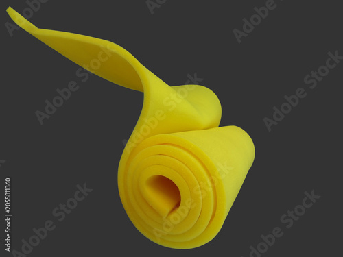 beautiful roll of dark yellow thin sponge foam material on gray background