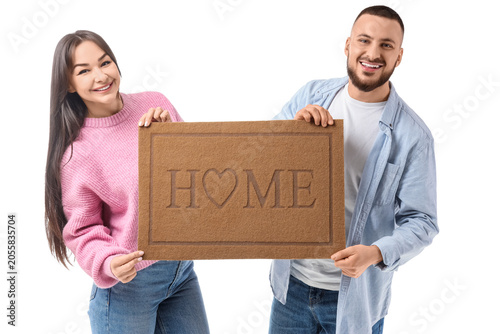 Young couple with doormat o...