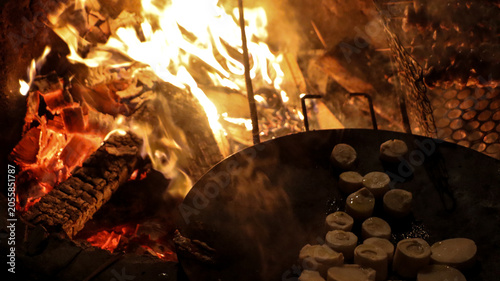 A cast iron pot being used for cooking over a wood fire.