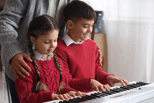 Children learning piano wit...