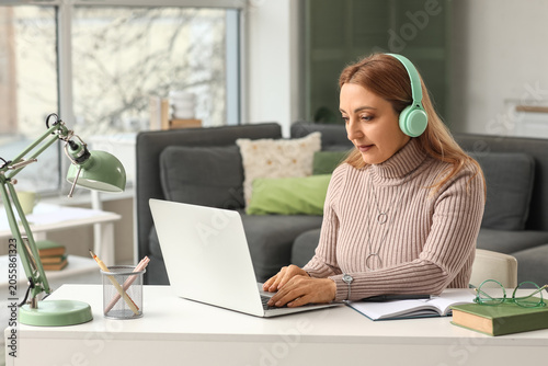 Mature woman in headphones ...
