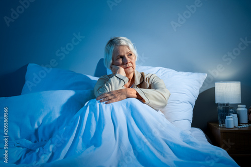 Fotografia Senior woman suffering from sleep deprivation in bedroom