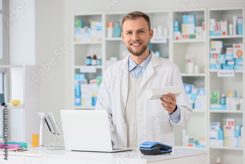Smiling male pharmacist hol...