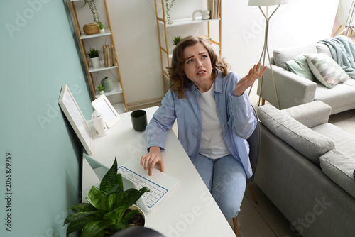 Fotografía Young woman suffering from noisy neighbours near desk at home