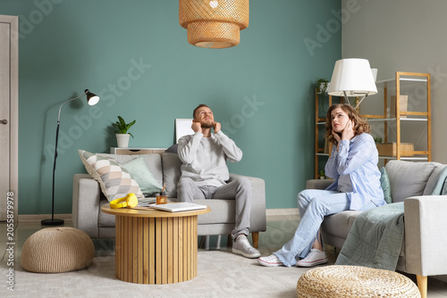 Fotografija Young couple covering their ears because of noisy neighbours at home