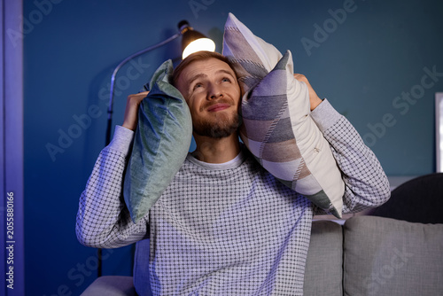 Young man covering his ears...