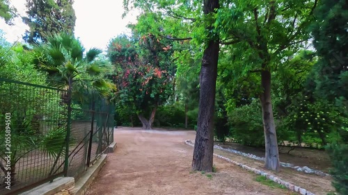 Attica Zoological Park in Athens, Greece with fence enclosure for exotic tropical birds captive wildlife point of view walking on trail footpath