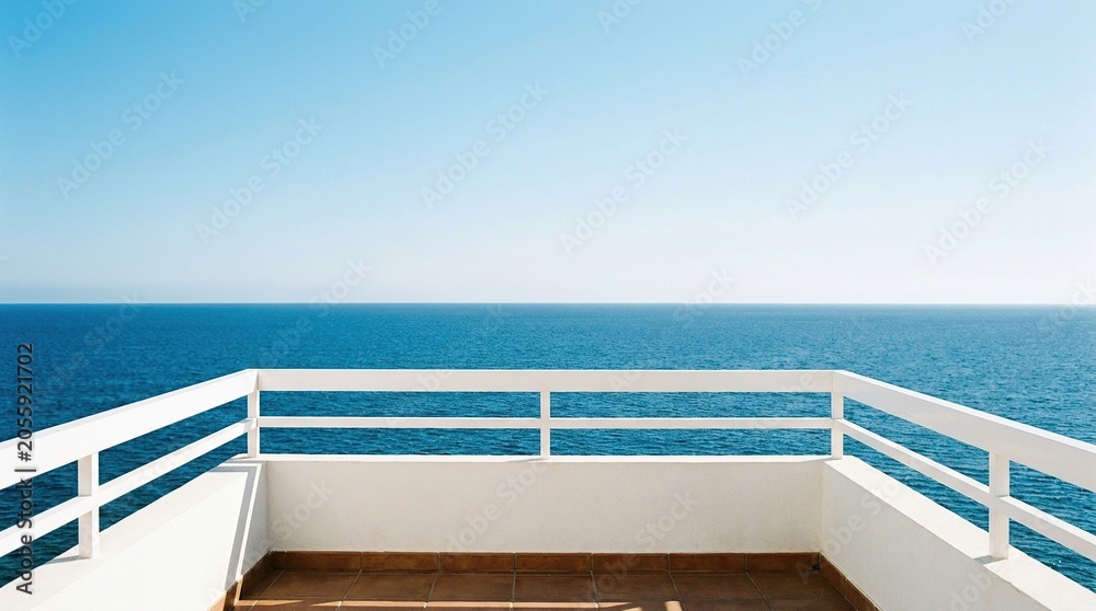Fototapeta premium Wide angle view of a minimalist balcony overlooking a calm blue ocean under a clear sky