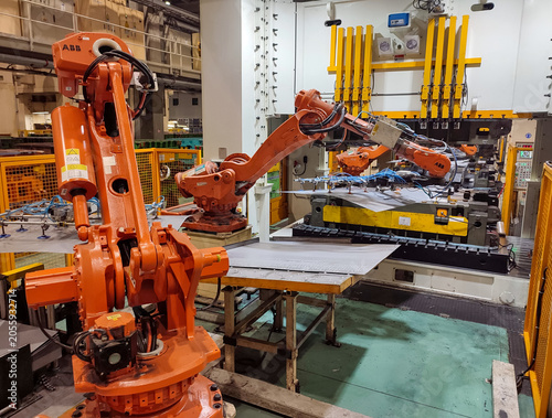 Automated robotic arms manipulation with metal sheets on industrial press shop stamping production line
