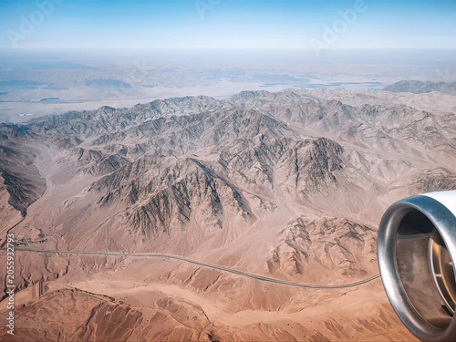 Stunning airplane passenger view of scenic desert mountains during commercial flight descent to Aqaba Jordan