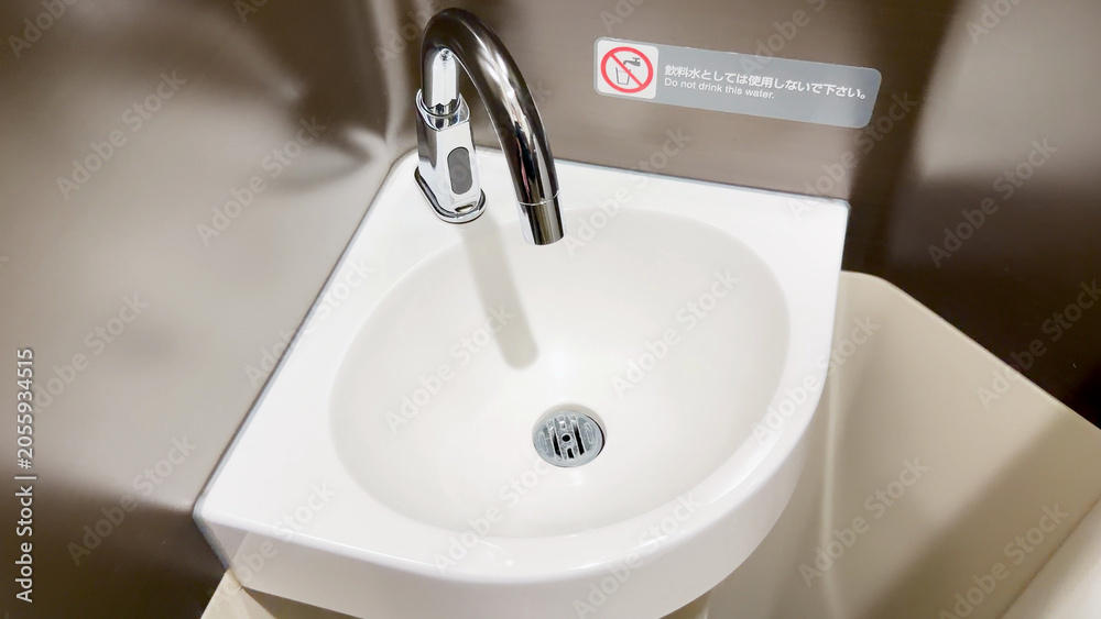 Fototapeta premium Automatic Sensor Faucet and Small Ceramic Sink in Japanese Public Restroom