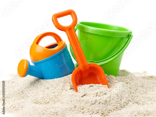 Colorful children sand toys set with green bucket watering can and orange shovel on white sand.