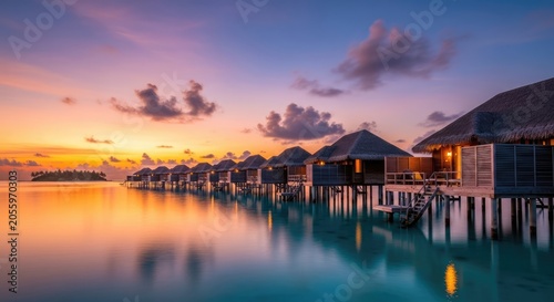 Overwater villas at a tropical island resort during vibrant sunset