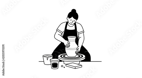 Woman working on pottery wheel in ceramics studio