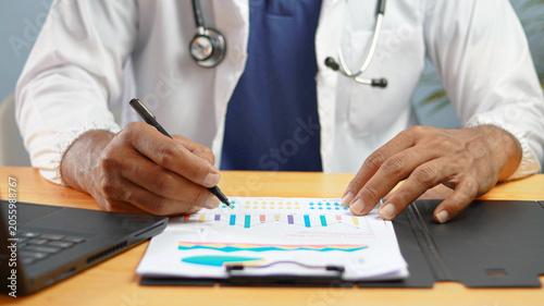 Billede på lærred Healthcare professional analyzing medical data and patient reports with charts and graphs