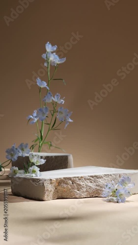 Light stone blocks and delicate blue flowers arranged in a warm neutral setting. Generous open space on both the stone surface and background allows room for products, branding or text overlays.