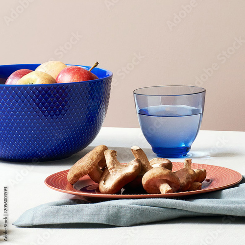 Mushrooms on plate with blue glass and fruit bowl
