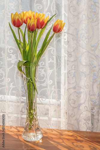 Vase of flowers on the table by the window close-up