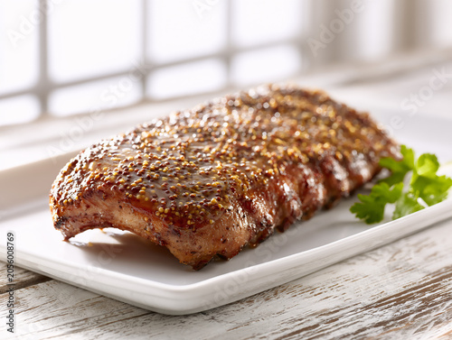 Sweet honey mustard glazed pork ribs served on a white porcelain platter