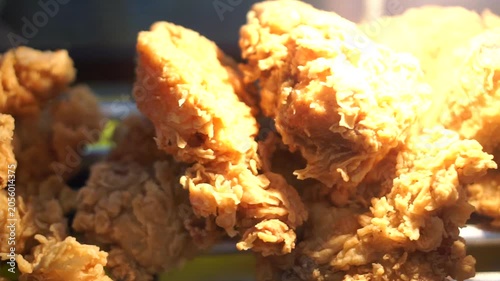 Detail of popular fast food featuring breast or thigh chicken coated in seasoned flour bright under warm lighting.
