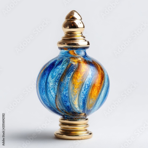Ornate Blue And Gold Perfume Bottle With Swirling Pattern And Golden Cap On White Background
