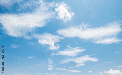 the sky is clear blue with fluffy white clouds, the sky is very bright, and the sun shines.