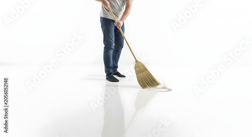 Person sweeping floor with broom in bright minimalist interior