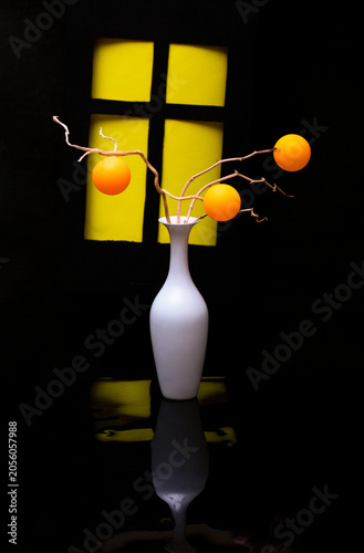 A bouquet with orange balloons against a window background