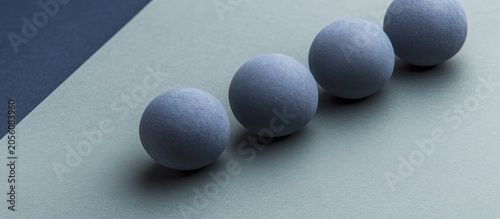 Blue spheres align on gray surface, dark backdrop; design concept
