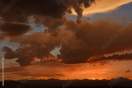 ominous storm clouds at  sunset  over long's peak and  the front range of the colorado rocky mountains, from broomfield,  colorado 