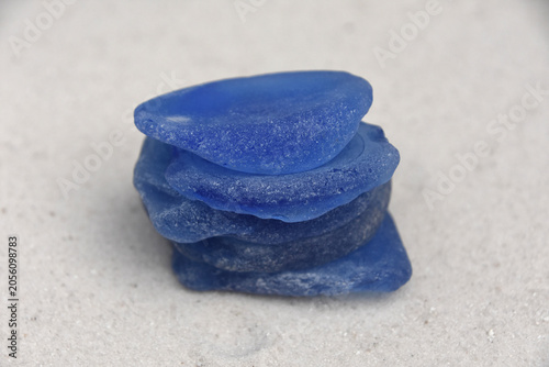 Brilliant Blue Sea Glass Stacked High on White Beach Sand
