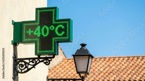 Urban heat wave city hot pharmacy sign glows near street lamp under summer sun. Warming crisis climate change. cooling temperature, sun climate weather, sunlight summer