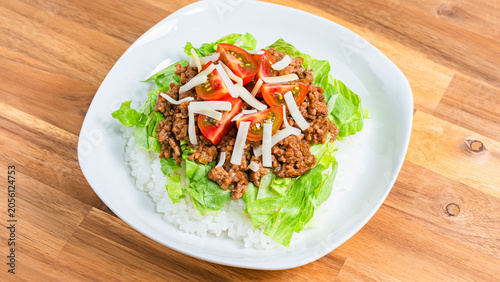 タコライス レタスとトマトをのせたチーズ入り沖縄料理の写真