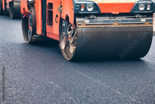 Obraz na plátně Asphalt Paving Machinery Conducts Road Repair in Urban Area Under Clear Blue Sky