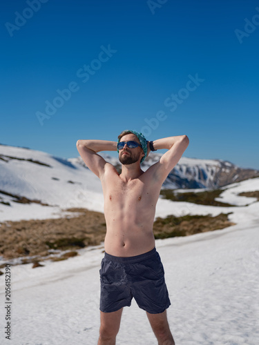 Foto Shirtless man practicing hardening on snowy slope in Carpathians