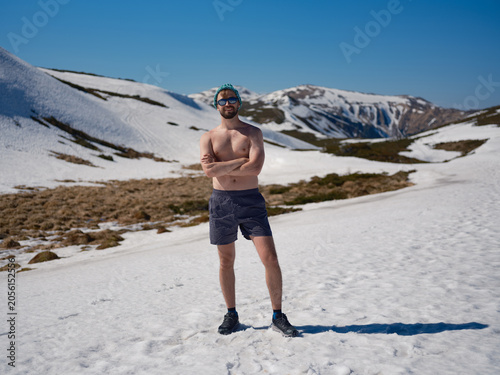 Quadro su tela Smiling shirtless man practicing hardening on snowy slope in Carpathians