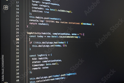 Fotografie Blurry computer screen displaying lines of colorful coding language on a dark ba