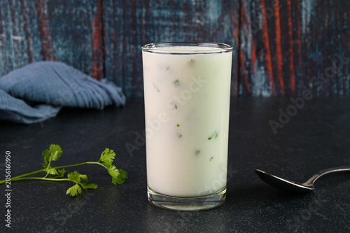 Serving buttermilk drink in glass cup.