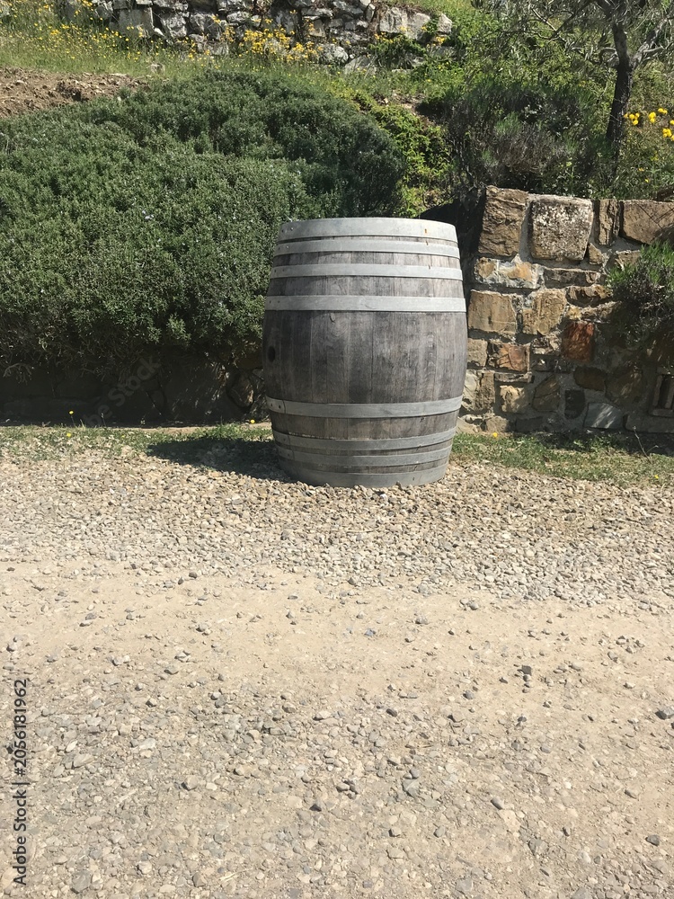 Naklejka premium Weathered Wooden Wine Barrel on Gravel Path in Tuscany