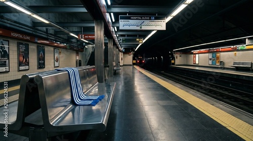Empty subway platform with scarf on bench