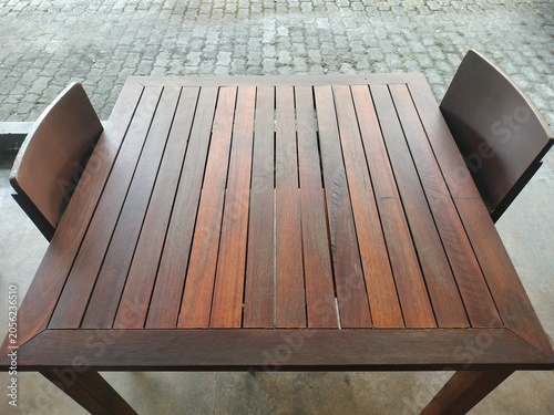 Tableau sur toile Square outdoor dining table made of rich brown hardwood slats, with two matching