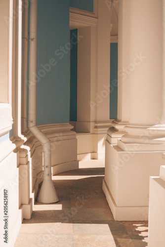 Quadro em tela Interior view of a classical colonnade featuring tall white columns, light blue walls and elegant architectural details