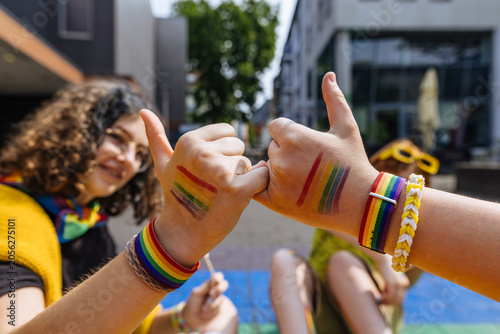 Friends making pinky promise at outdoor pride parade