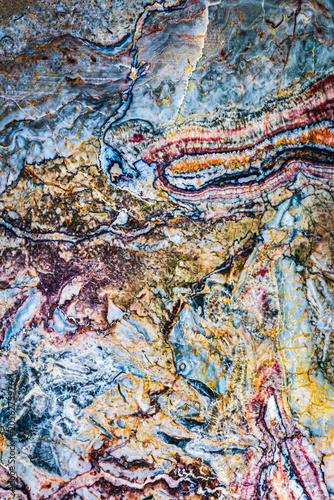 Natural stone surface showing lines of different colors and textures in a layered design