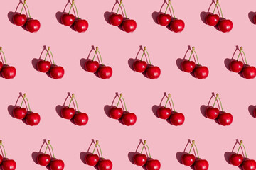 Pattern of fresh cherries on pink background
