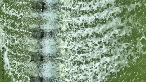 Φωτογραφία An aerial view of a paddle wheel aeration system creating strong water movement, illustrating modern aquaculture practices, oxygenation efficiency, pond management, and sustainable seafood production