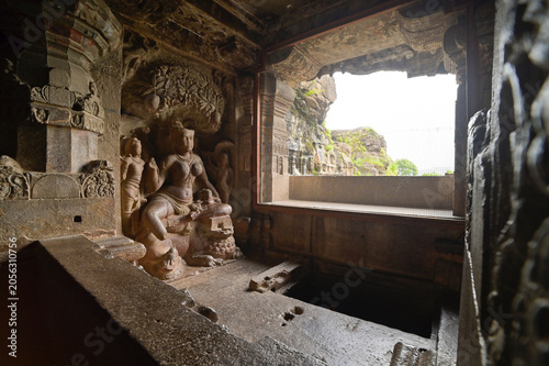 Ancient statue of female Hindu deity squatted under a tree, hand carved in granite stone at Ellora Caves; a UNESCO world heritage site, Maharashtra, India,