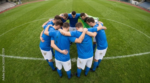 Team huddles together on a green field before a match