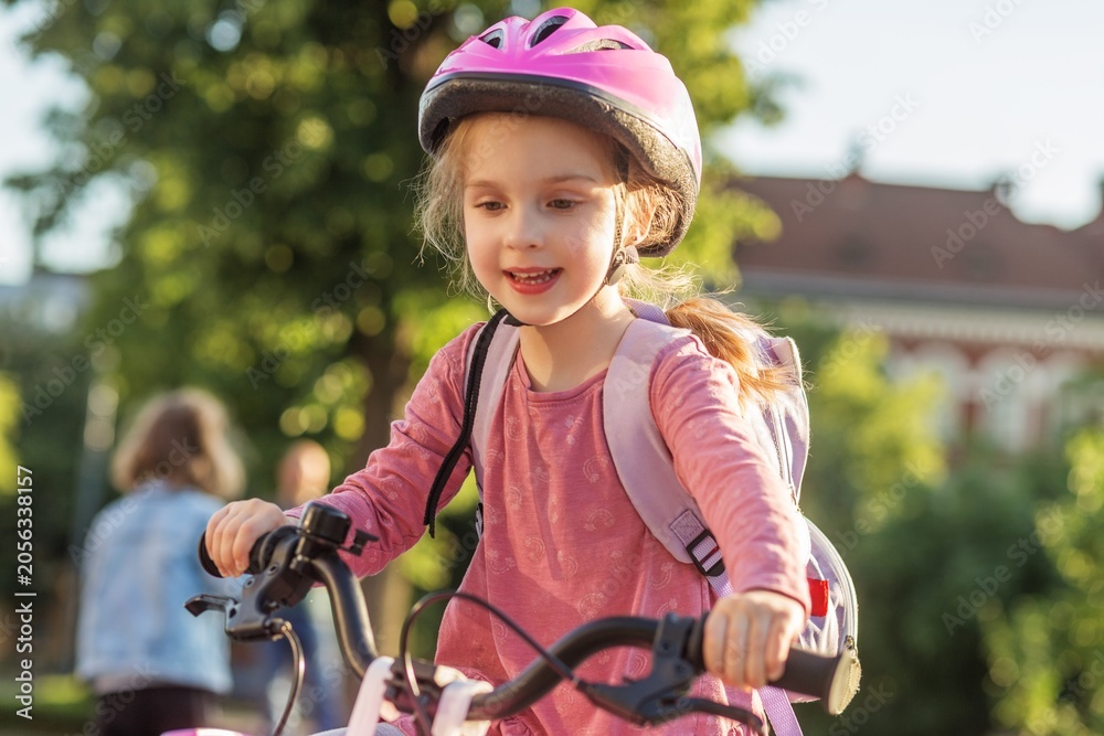 Obraz premium School Child Riding Bicycle to School With Backpack