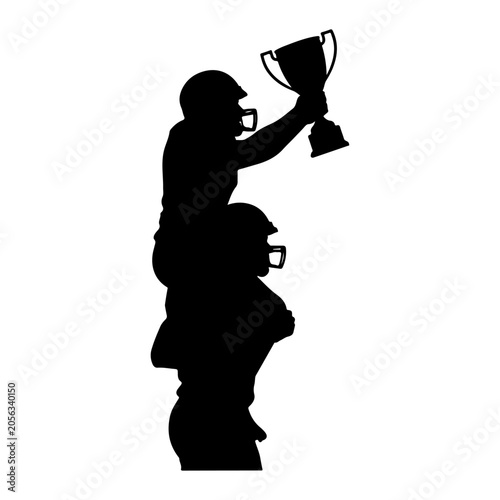 Tablou pe pânză Silhouette of a football player holding a trophy aloft on another players shoulders